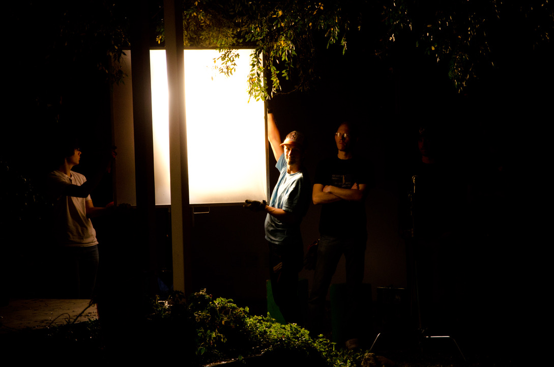 NIGHT EXTERIOR — CREW BEHIND A LARGE SOFTBOX